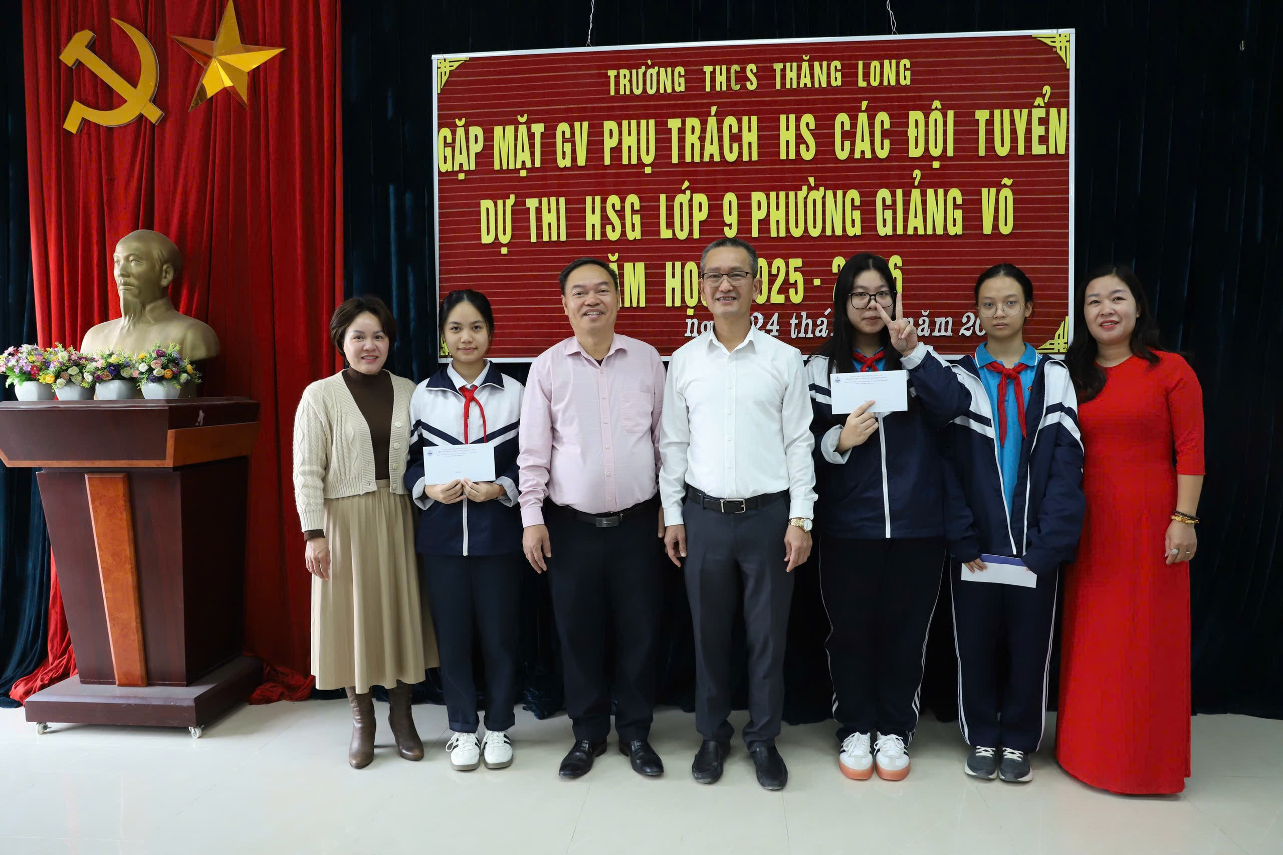 A group of people standing in front of a red bannerAI-generated content may be incorrect.