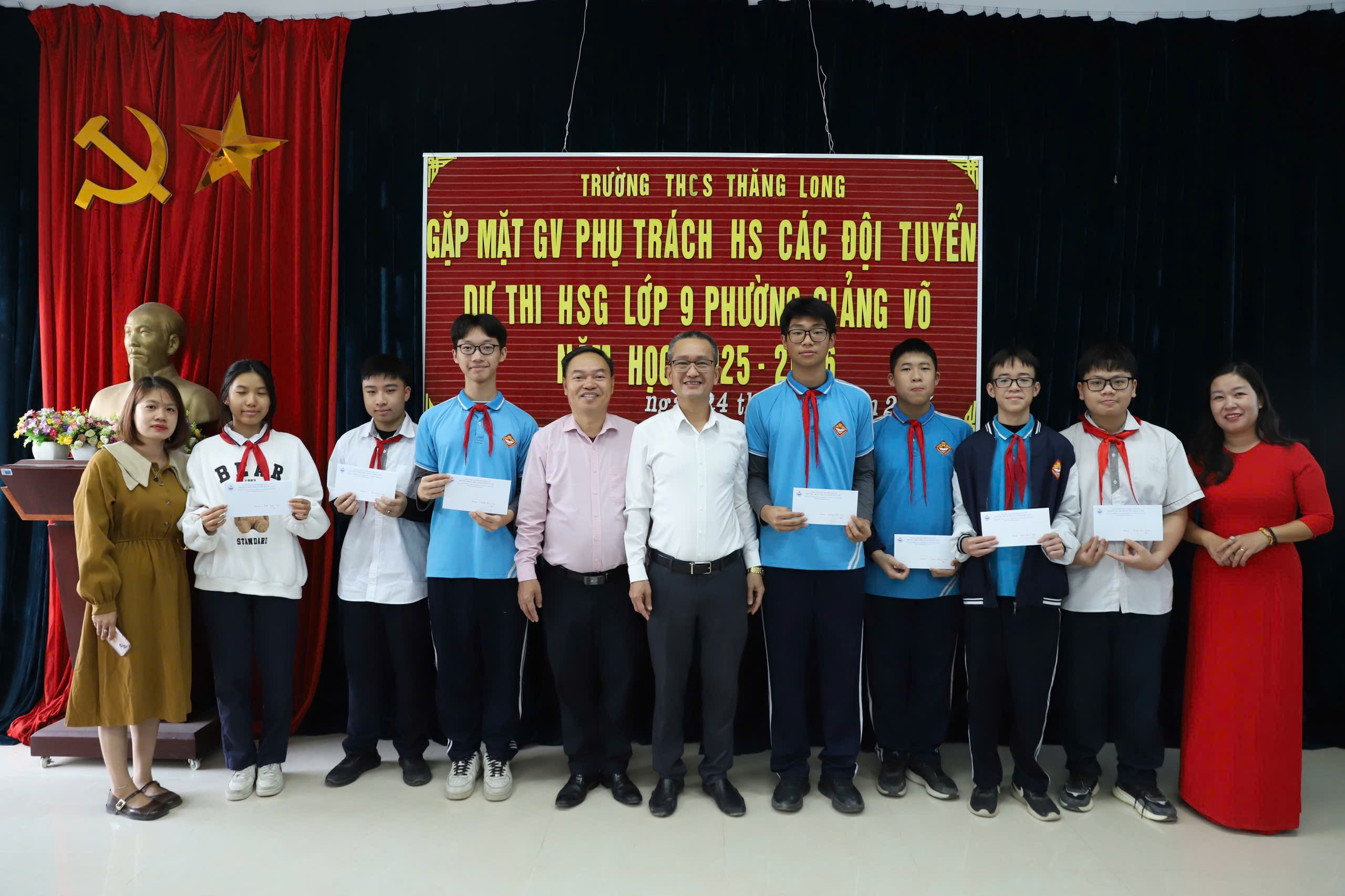 A group of people standing in front of a red bannerAI-generated content may be incorrect.