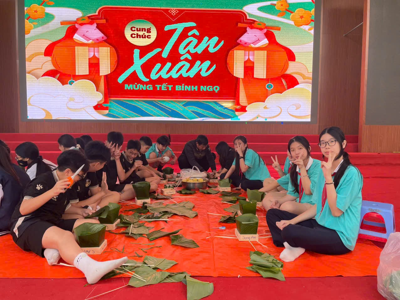 A group of people sitting on a red carpet

AI-generated content may be incorrect.