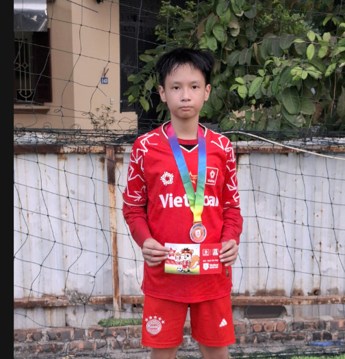 A child wearing a medal

Description automatically generated